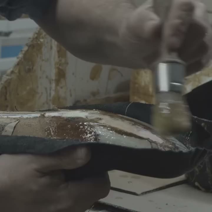 With skilful gestures, the craftsman brushes the glue on the insole and pastes…