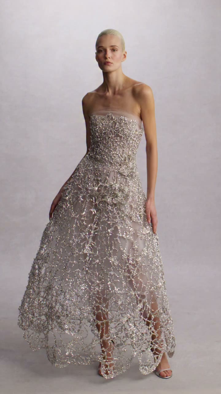 Oscar de la Renta Fall 2026. Crystals suspended on invisible thread trace the…