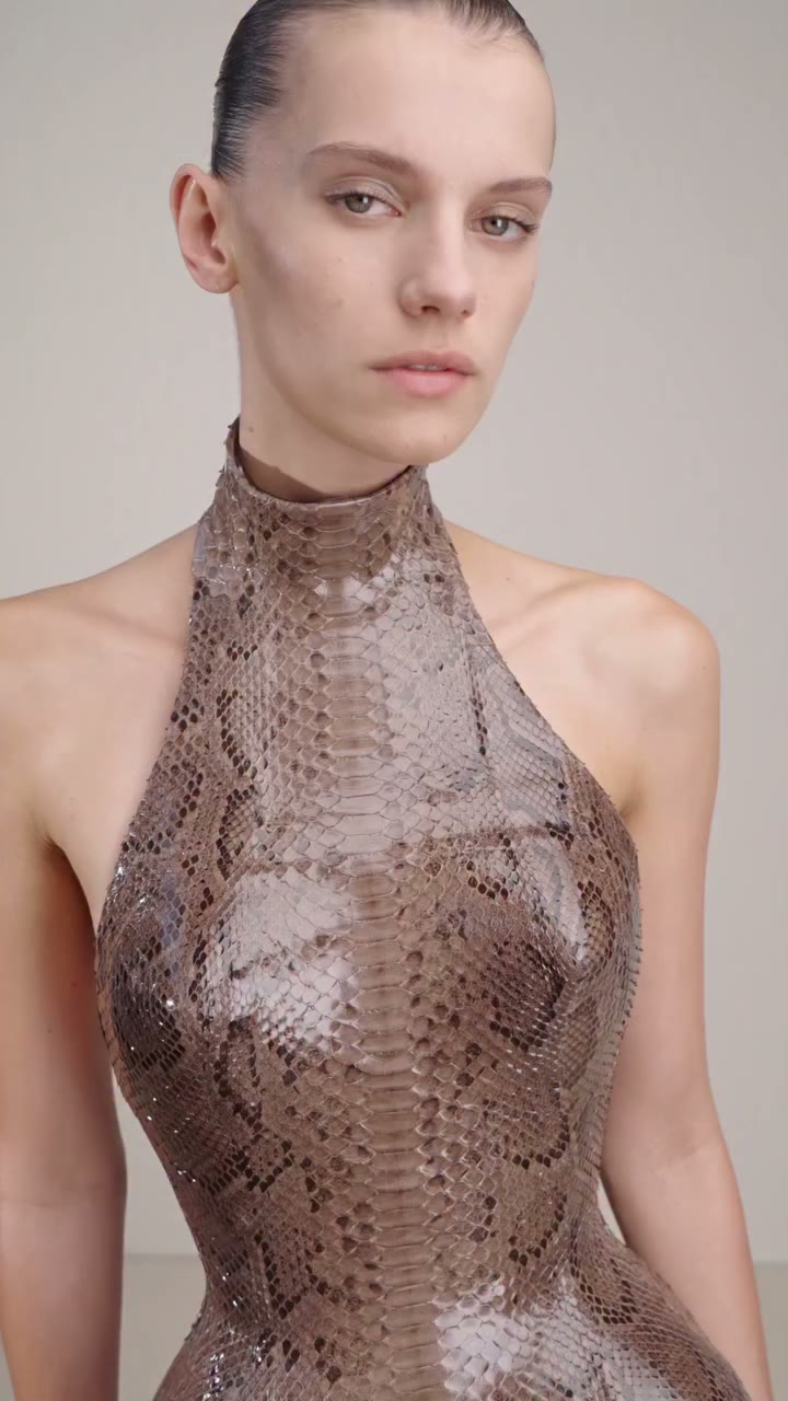 A python corset with a sculptural halter collar, paired with a matching long…