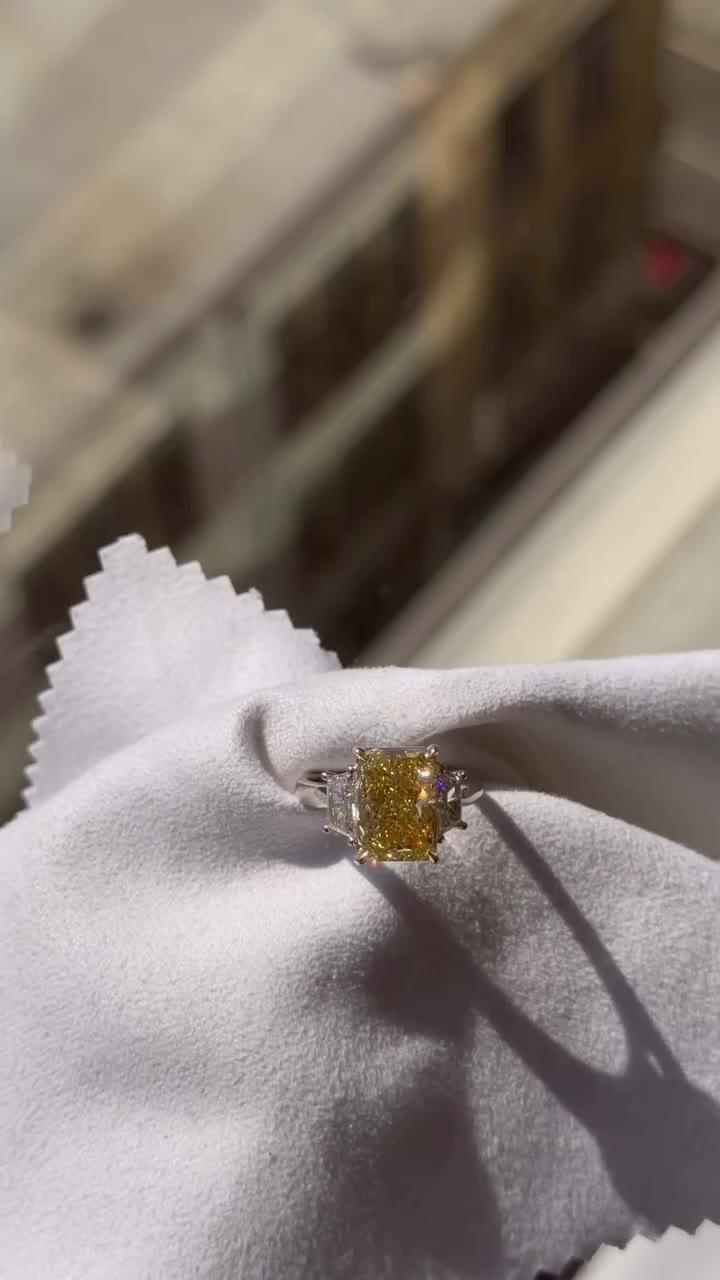 Five carat radiant cut, in a classical, timeless setting with two side…