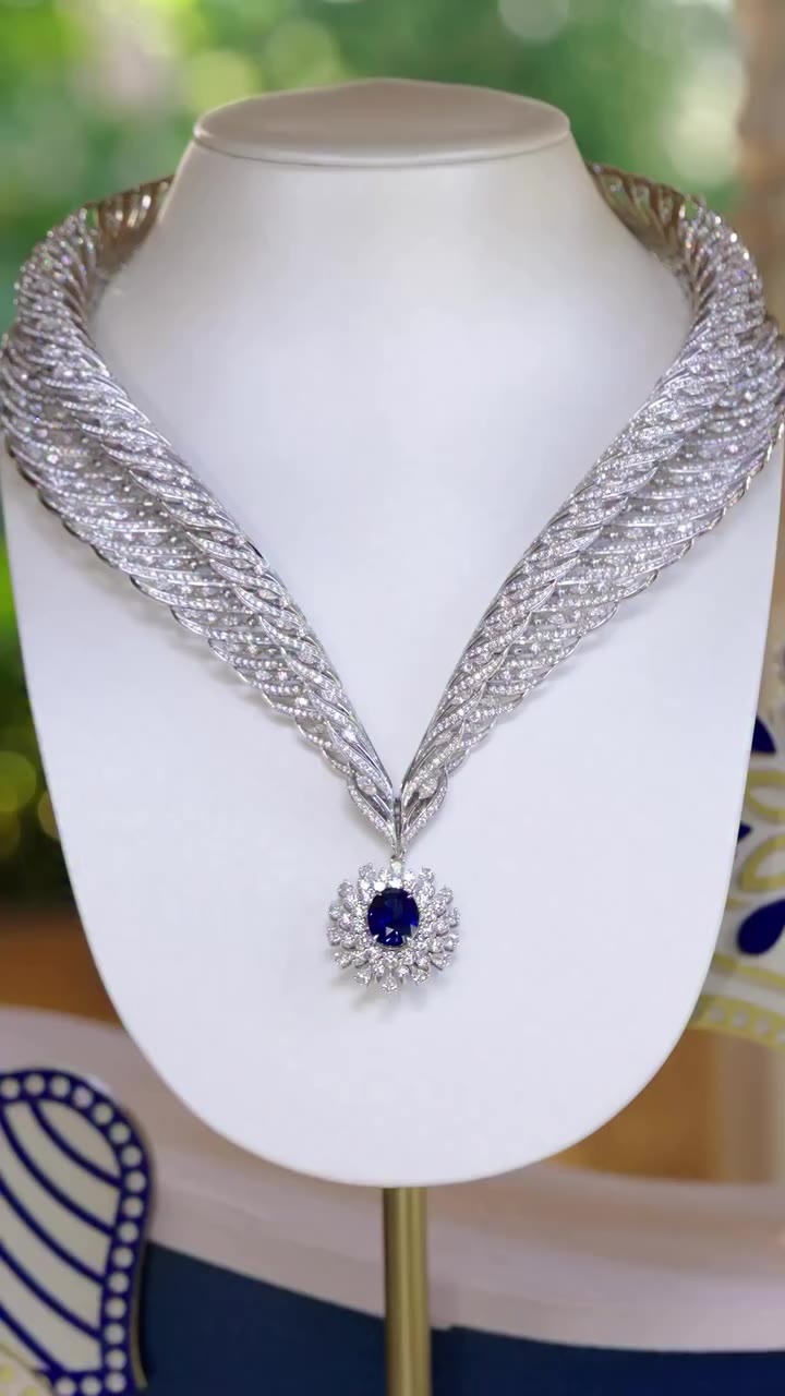 A royal blue sapphire resting within a silhouette that curves like a quiet…