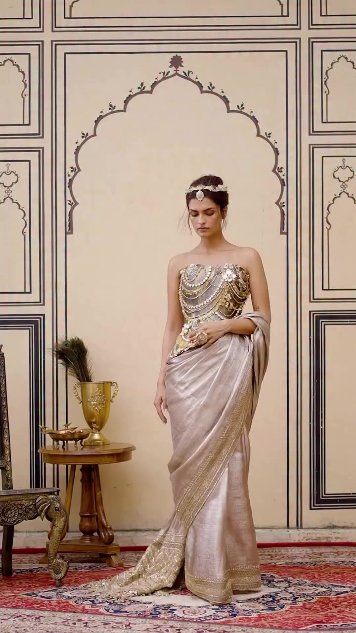 𝐏𝐨𝐥𝐤𝐢 The Gulnaar Tissue Brocade Metal Saree Set pairs a rose-gold tissue…