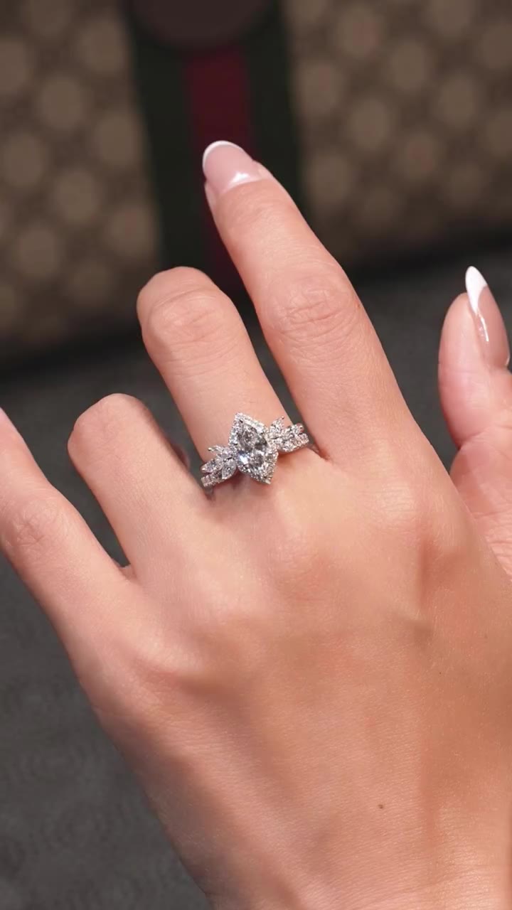 A little radiance to keep. ✨ Marquise halo over a marquise-cluster open band…