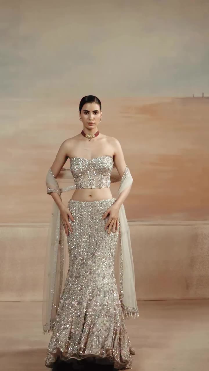 Subtle metallic tones meet sheer, fluid tailoring in a contoured frame. The…
