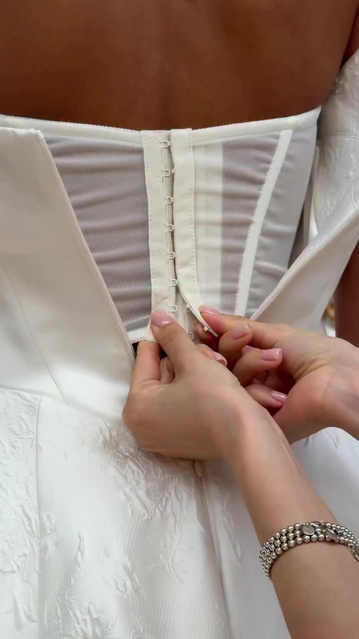 A sculpted corset, a full skirt, a name inspired by an icon — Jackie was…