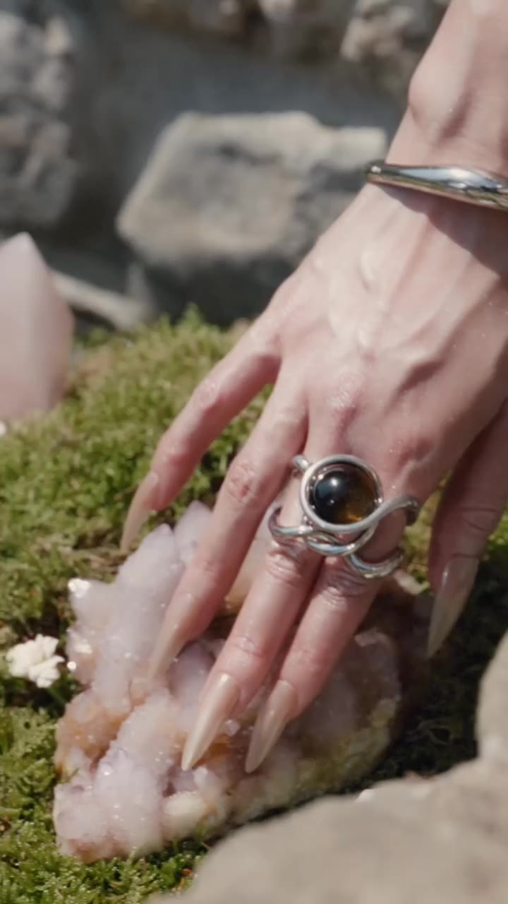 MAM ANDROMEDANS COLLECTION Set against silver, Tiger Eye reveals its warm…