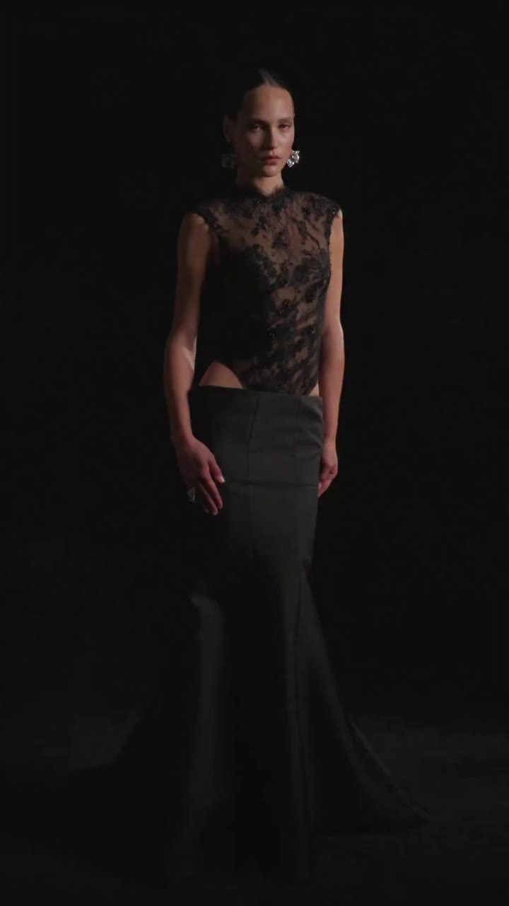 A hand-beaded black lace bodysuit, paired with a seamed skirt that flares at…