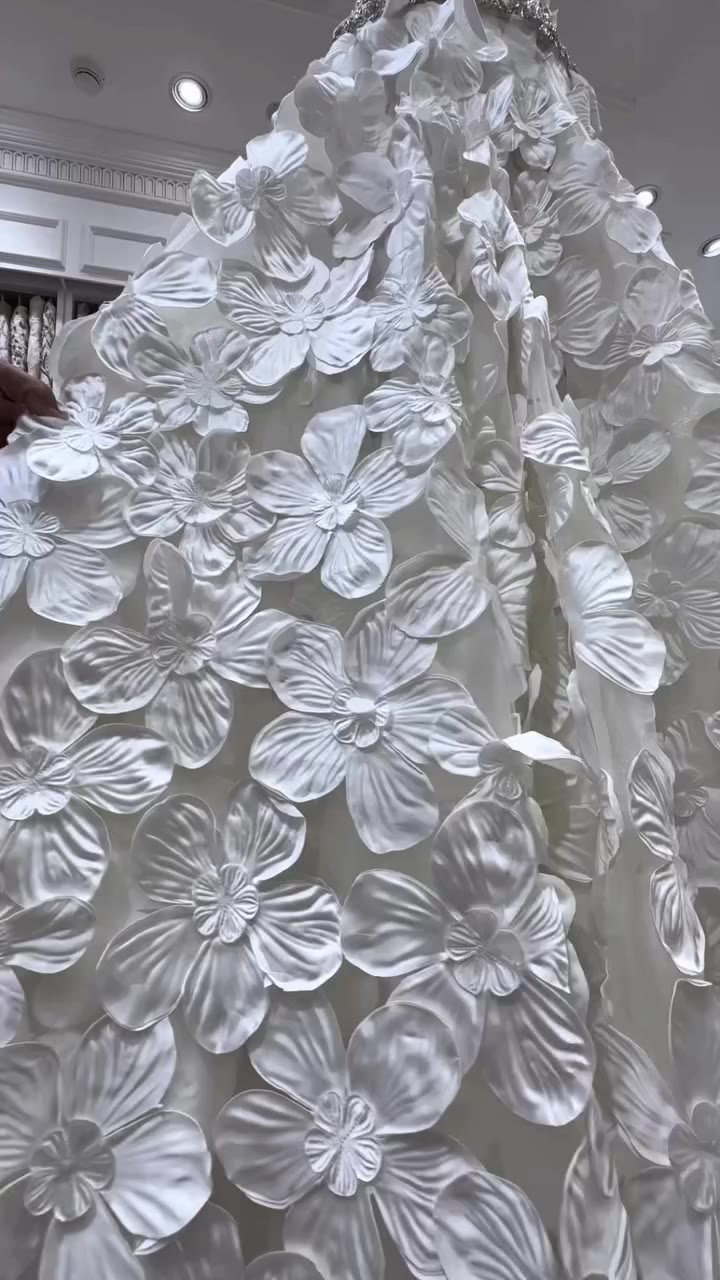 Striking 3D floral appliqués gracefully cascade into a heavily…