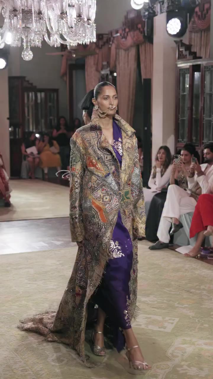 A long coat assembled from multiple patchwork panels, layered with a rich…