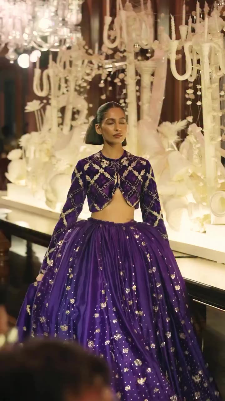 A voluminous organza skirt illuminated with delicate mukaish work, paired with…