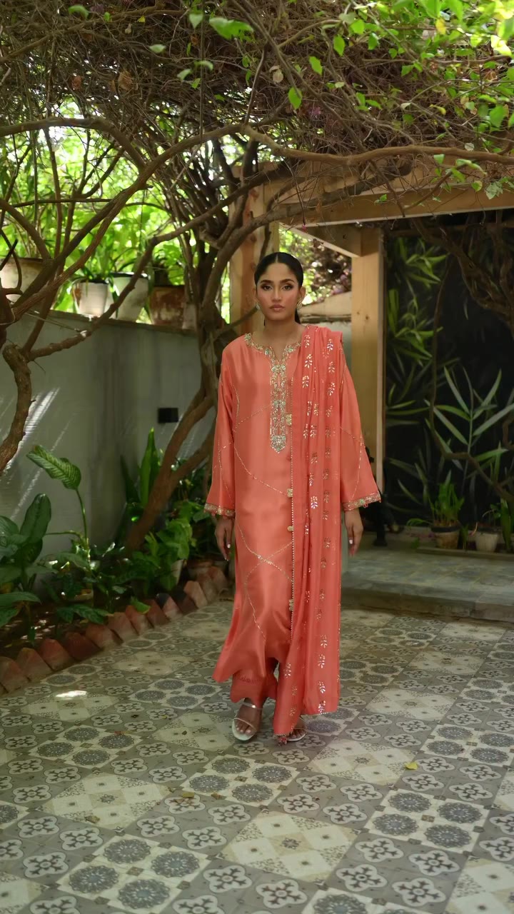 Fresh coral silk, delicately adorned with zardozi handwork and paired with a…